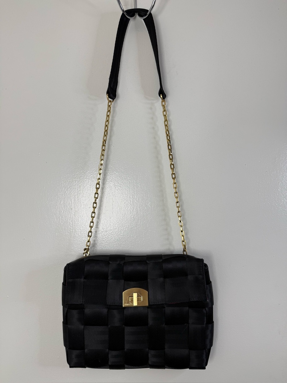 Harvey’s black seatbelt bag with gold chain strap